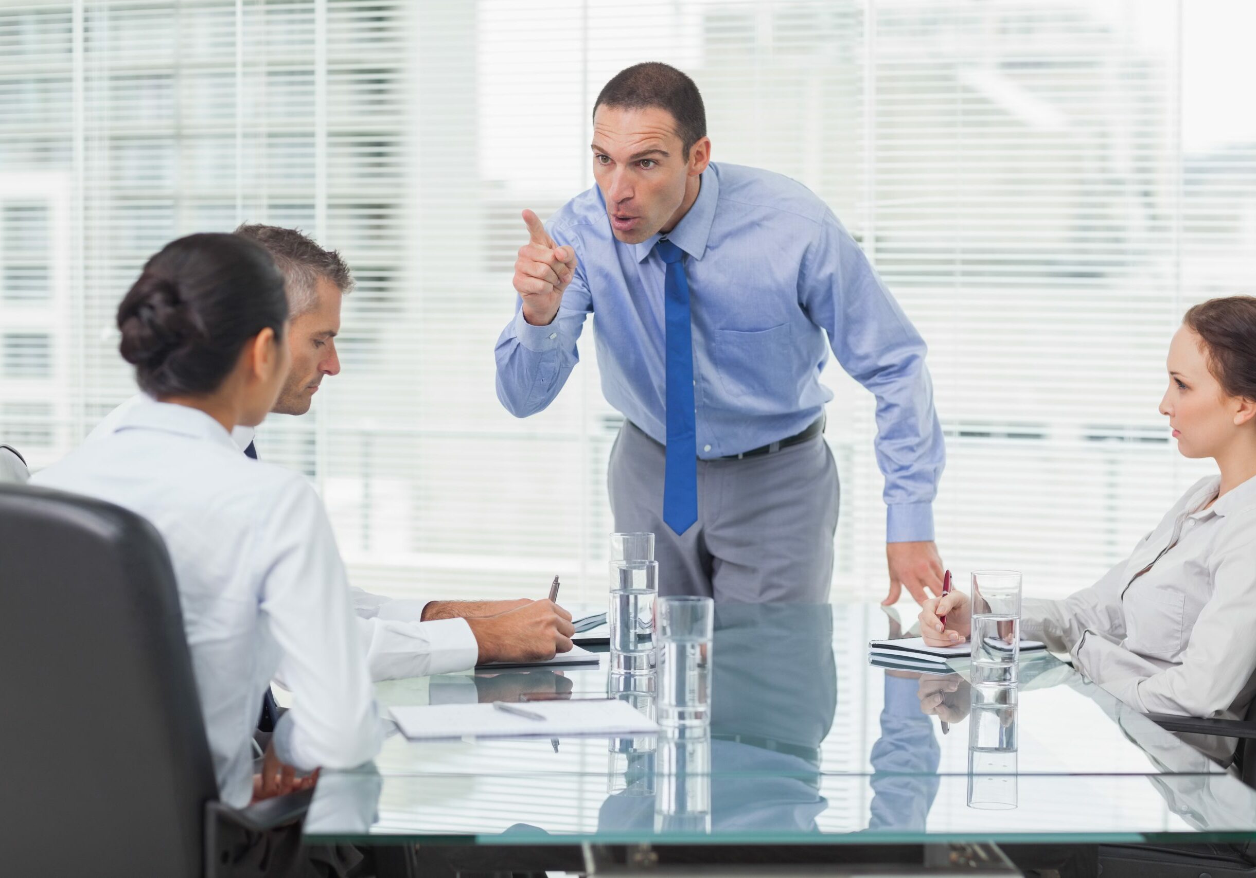 Angry executive pointing out his employee in bright office